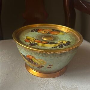 Vintage August Storck gold tin featuring fruit, with lid